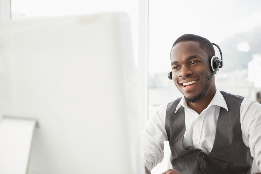 Smiling businessman with headset interacting in his office Smiling businessman with headset interacting in his office